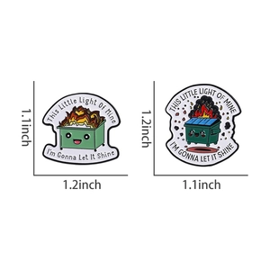 Detailed view of dumpster fire enamel pins with humorous quotes and measurement labels