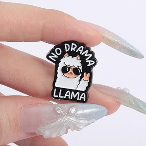 Close-up of No Drama Llama enamel pin with a cute white alpaca wearing sunglasses