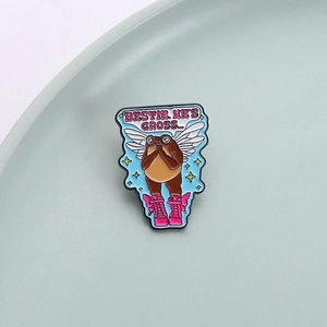 Broche grenouille rigolote avec bottes roses et texte BESTIE HE'S GROSS sur plat