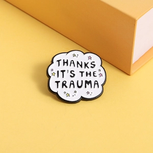Cloud enamel pin with 'THANKS IT'S THE TRAUMA' text and stars on orange background