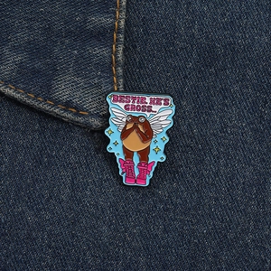 Détail d'un pin's en émail grenouille rigolo avec bottes roses sur tissu en jean