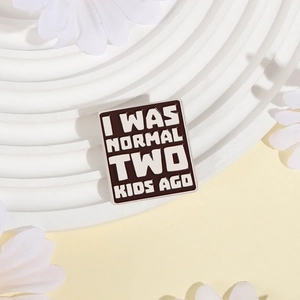 Macro shot of square enamel brooch featuring funny text I Was Normal Two Kids Ago