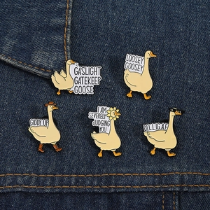 Détail de pin's en émail oie rigolos fixés sur un vêtement en denim bleu classique