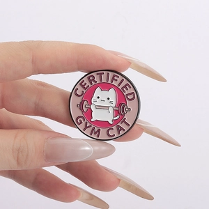 Détail d'un pin's en émail rose illustrant un chat blanc soulevant des haltères au gym
