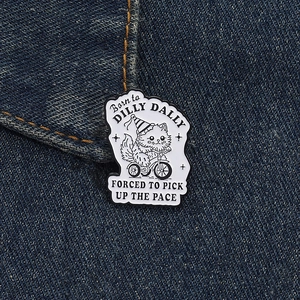 Detailed view of an enamel cat brooch on denim fabric, featuring a cat on a tricycle