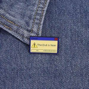 Détail macro d'un pin's émaillé avec design d'erreur système sur tissu en jean