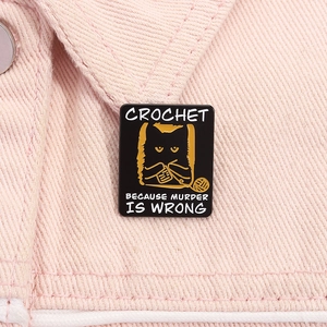 Détail du pin's émaillé chat noir crochet avec citation sur veste en jean rose