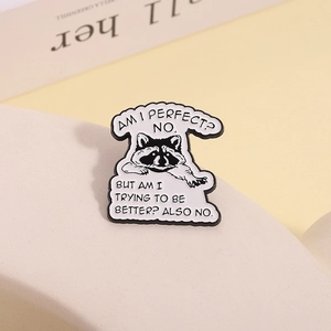 Detail shot of raccoon enamel pin with humorous English quote on polished metal surface