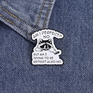 Macro detail of raccoon enamel pin with funny quote on a blue denim background
