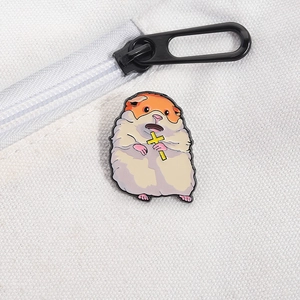 Gros plan d'un pin's émaillé de hamster avec croix sur un sac en toile blanc