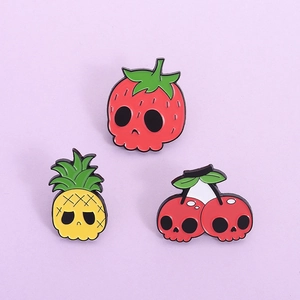 Set of three creative enamel pins featuring fruit skulls like strawberry, pineapple, and cherry