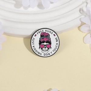 Geometric round enamel pin with skull motif and Free Hugs text on minimalist background