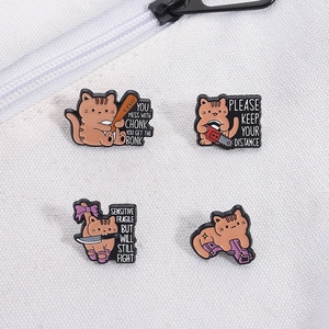 Détail de quatre épingles en émail de chat orange drôles avec texte humoristique sur toile