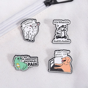 Détail de quatre broches en émail rigolotes représentant un chien, une grenouille et un agneau