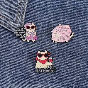 Détails de trois broches en émail chat de dessin animé sur fond en tissu denim bleu