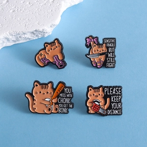 Funny orange cat enamel pins set featuring four cartoon cats with humorous weapons and text
