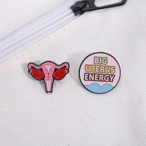 Detail of Big Uterus Energy enamel pin set with pink boxing gloves on a white bag