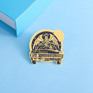 Retro car enamel brooch with angel wings and halo design on light blue textured background