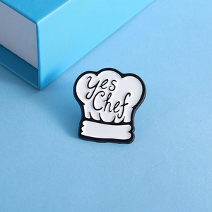 Détail du pin's en émail toque de chef avec texte yes Chef sur fond bleu