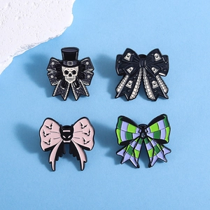Set of four Halloween enamel pins featuring skulls, bats and ghosts on colorful bows