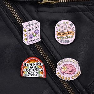 Pink mental health enamel pins set with healing quotes on a black leather jacket