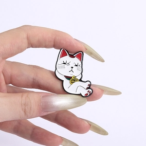 Vue macro d'un badge en émail de chat blanc mignon avec une cloche dorée