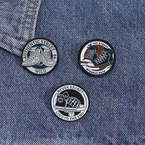 Detailed macro of three round enamel pins with vintage high-top canvas shoe patterns