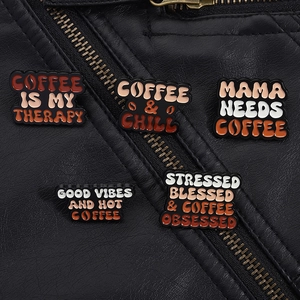 Détail de broches en émail sur le thème du café fixées sur une veste en cuir noir