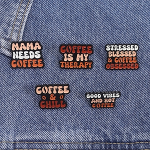 Five-piece coffee-themed enamel pins set with retro brown tones on blue denim background