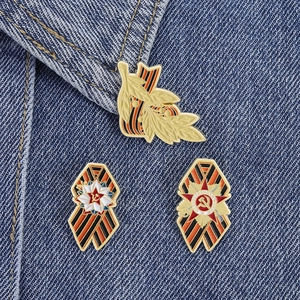 Detailed view of Soviet Victory Day enamel pins with St. George ribbon on denim fabric