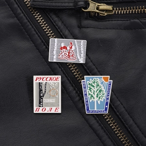 Detailed macro view of Russian enamel pins on a black leather jacket texture
