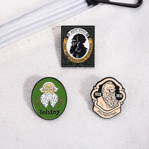Macro detail of Leo Tolstoy enamel pins set displayed on white canvas fabric