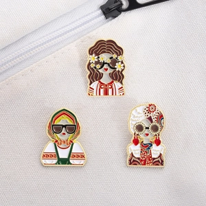 Vue macro de trois pin's en émail de style dessin animé sur un sac en toile texturée