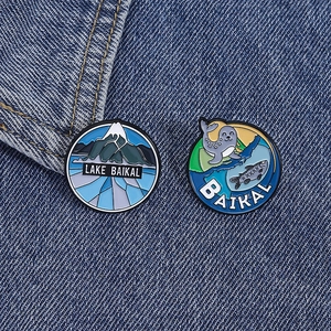 Vue détaillée des épinglettes en émail du lac Baïkal avec motifs de montagne et phoque