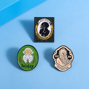 Detailed close-up of Tolstoy metal enamel badges with historical portraits on blue background