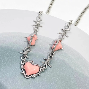 Pink heart necklace with silver wire design on elegant minimalist display