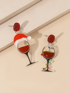Detailed macro view of asymmetric Christmas wine glass earrings with glitter finish