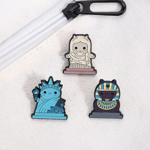 Detailed view of creative cat enamel pins styled as Goddess and Pharaoh on white canvas bag