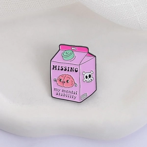 Detail of pink milk carton enamel pin with Missing my mental stability text