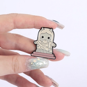 Detailed macro view of a cute enamel cat brooch held in hand to show the compact size