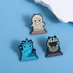 Set of three cute cartoon cat enamel pins featuring Statue of Liberty and Pharaoh designs