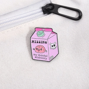 Detailed macro view of a pink enamel pin showing 'MISSING mental stability' text and graphics