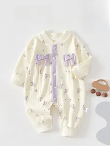 Detail of baby romper with purple grape print and decorative 3D bows on soft knit fabric