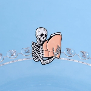 Gothic punk enamel skull brooch hugging hip shape on light blue background for Halloween