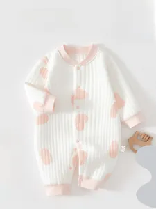Détail de la grenouillère bébé en tissu côtelé blanc avec pois roses et boutons-pression