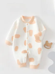 Detail of baby long sleeve romper with polka dots and soft ribbed cotton texture