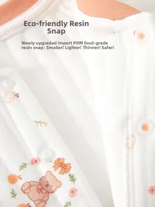 Detail of eco-friendly resin snap fasteners on a soft cotton baby bodysuit with bear print