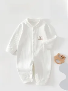 Detail of soft ribbed cotton baby romper with cute bear embroidery and snap button closure