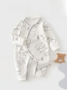 Detail of white cotton baby romper featuring cartoon hippo prints and side-tie closure