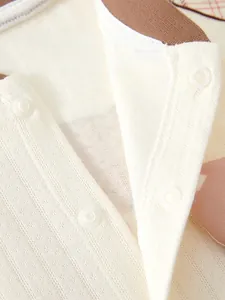 Détail des boutons en résine et de la texture tricotée sur le body en coton pour bébé